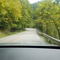 A dashboard-angle from the passenger side of an SUV, looking at the damaged guardrail where Logan wrecked